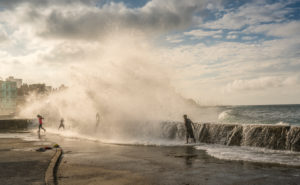 Gigantic wave hitting Malecon Havana, playing children, splashing surf, drops of water, Cuba Gigantic wave hitting Malecon Havana, playing children, splashing surf, drops of water, Cuba